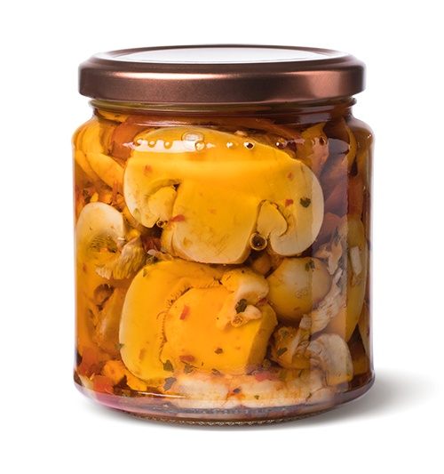 vaso in vetro con funghi tagliati e conditi piccanti in olio di girasole